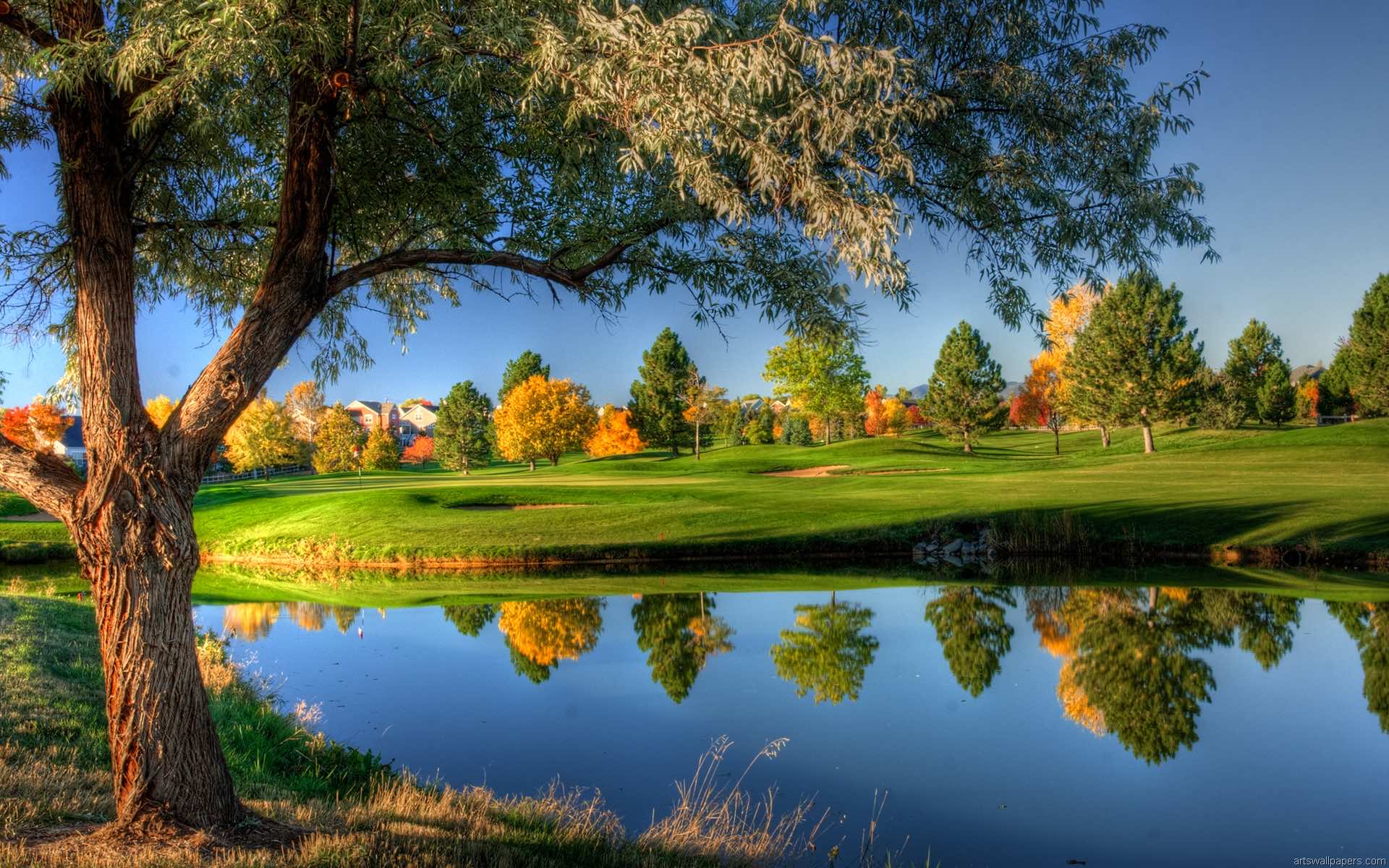 Scenic golf course landscape with pond reflection during autumn