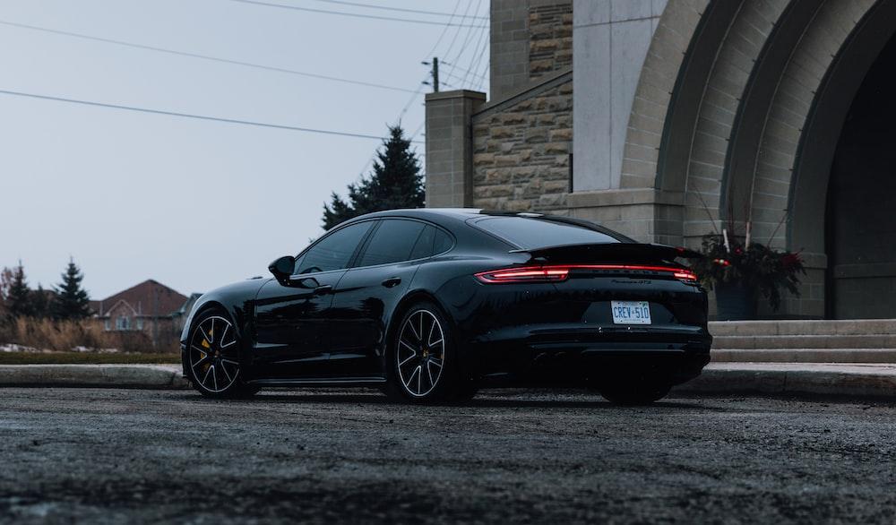 Black Porsche Parked Near Brown Brick Wall Photo Car