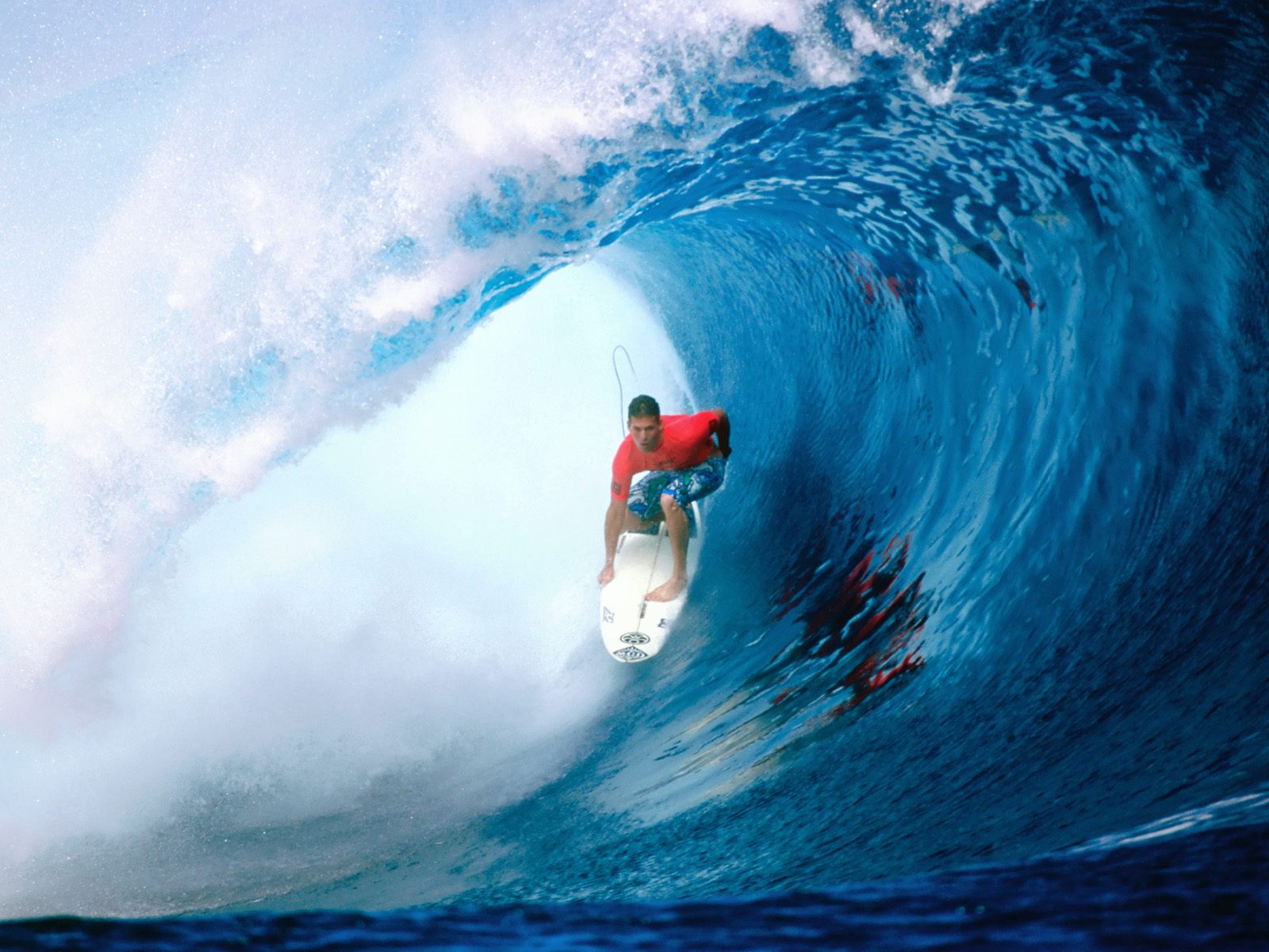 A surfer rides a powerful wave in a vibrant blue ocean, showcasing the thrill and dynamism of surfing