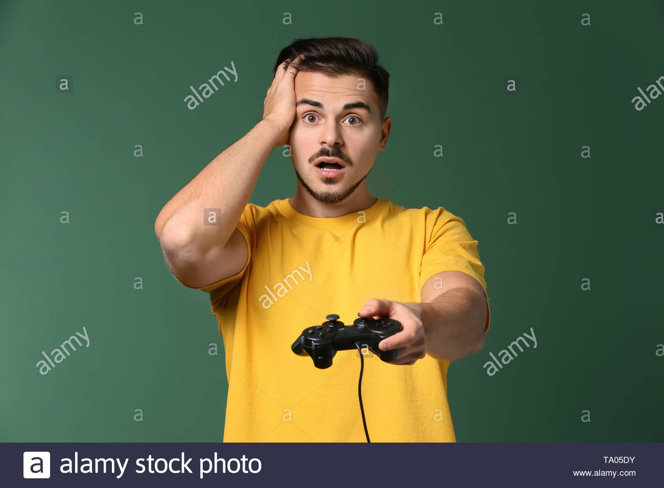 Young Man After Losing Video Game On Color Background Stock Photo