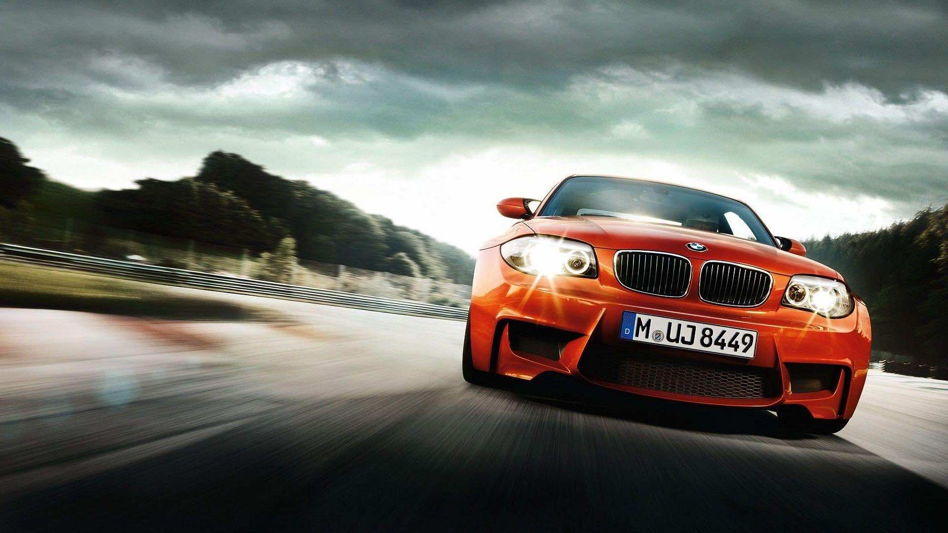 Orange BMW 1 Series M Coupe speeding on a racetrack