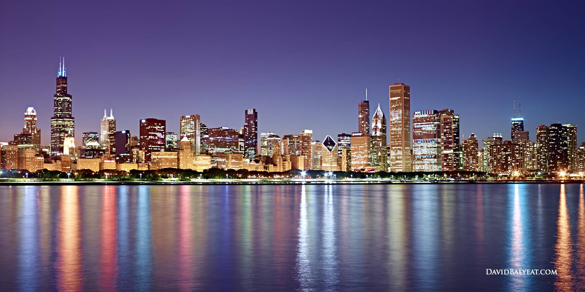 Chicago skyline at night with colorful reflections on Lake Michigan
