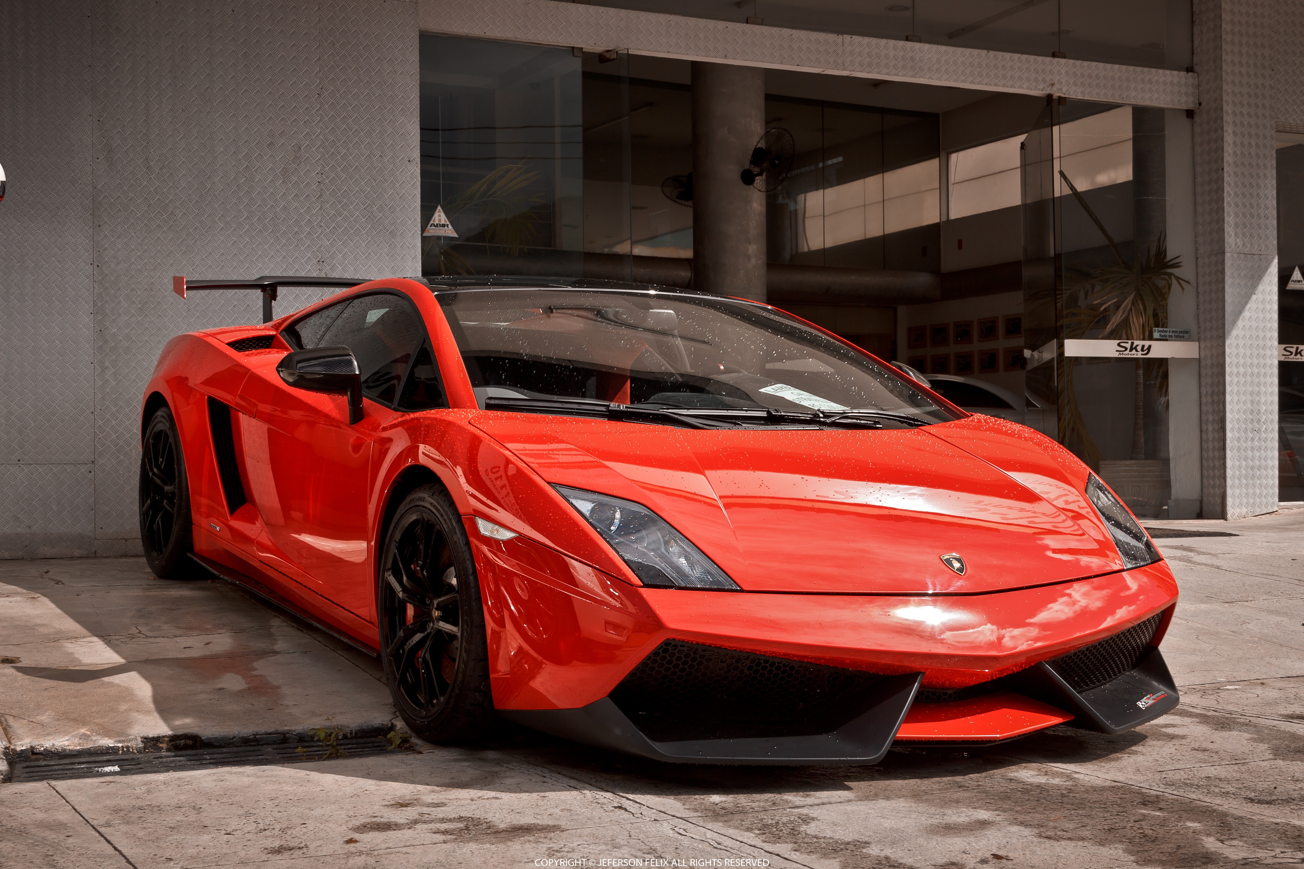 A vibrant red Lamborghini Gallardo, parked and gleaming, showcasing its sleek design and sporty features