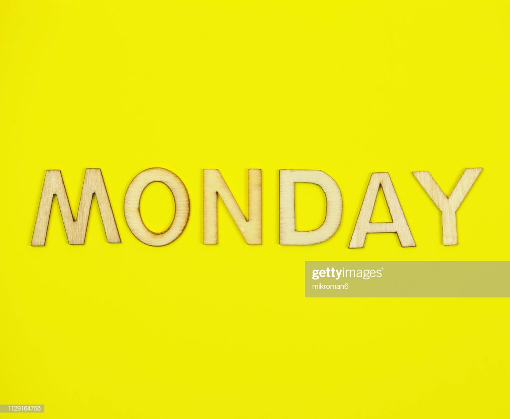 Shot Of Yellow Paper Background With Word Monday Stock Photo
