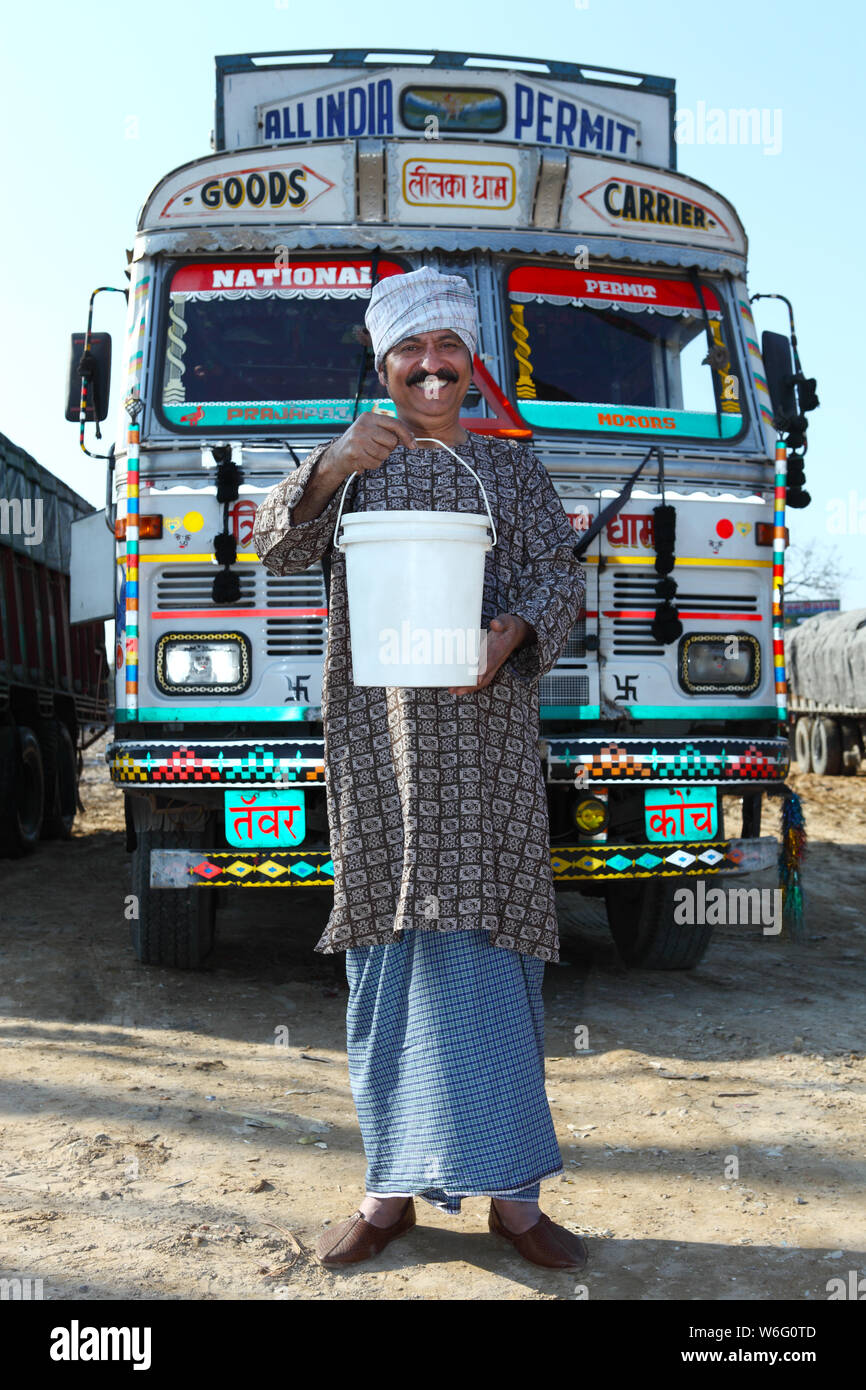 Truck Driver Showing A Bucket Of Motor Oil Stock Photo