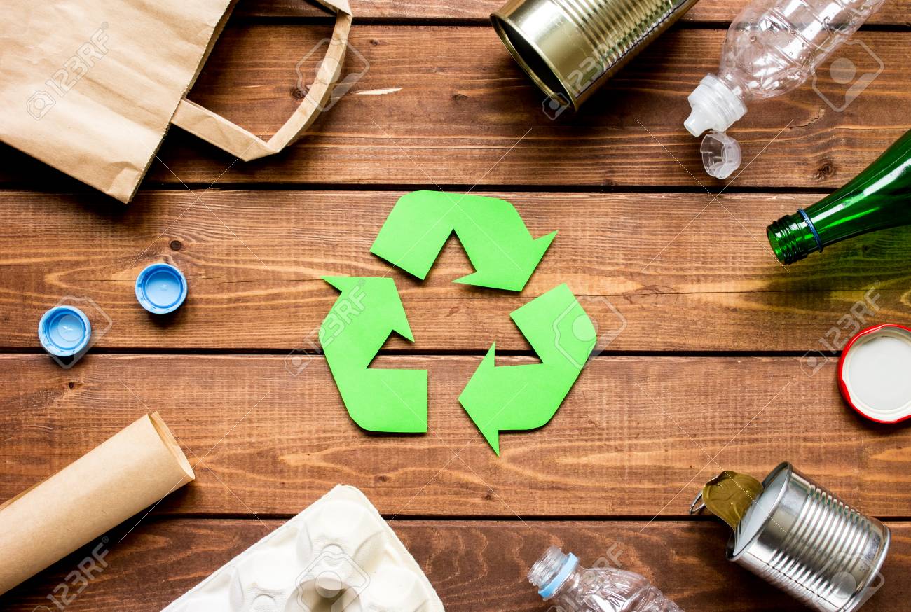 Waste Recycling Symbol With Garbage On Wooden Background Top