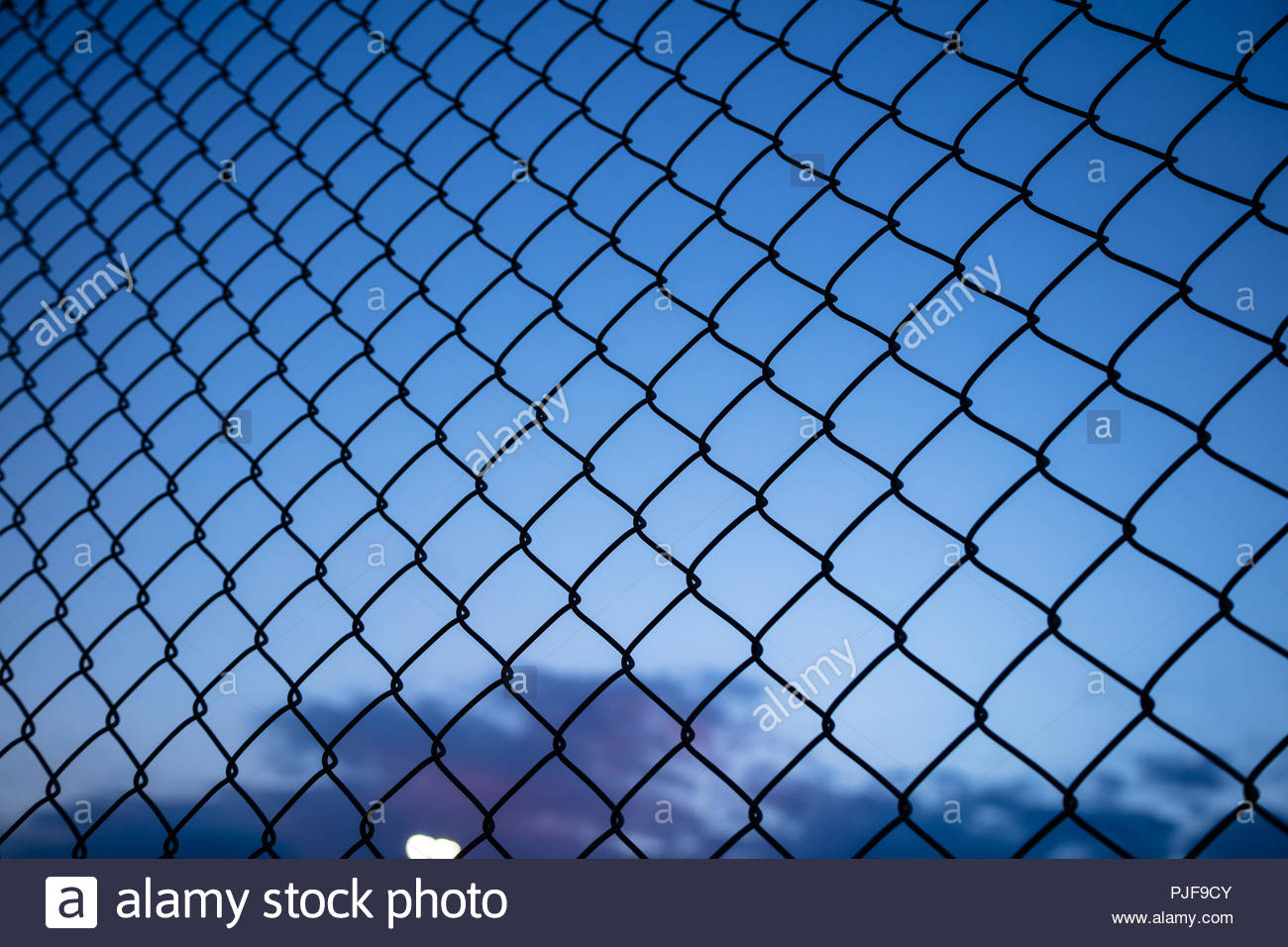 Dark Blue Sky Through Wire Mesh Fence Blur Background Close Up
