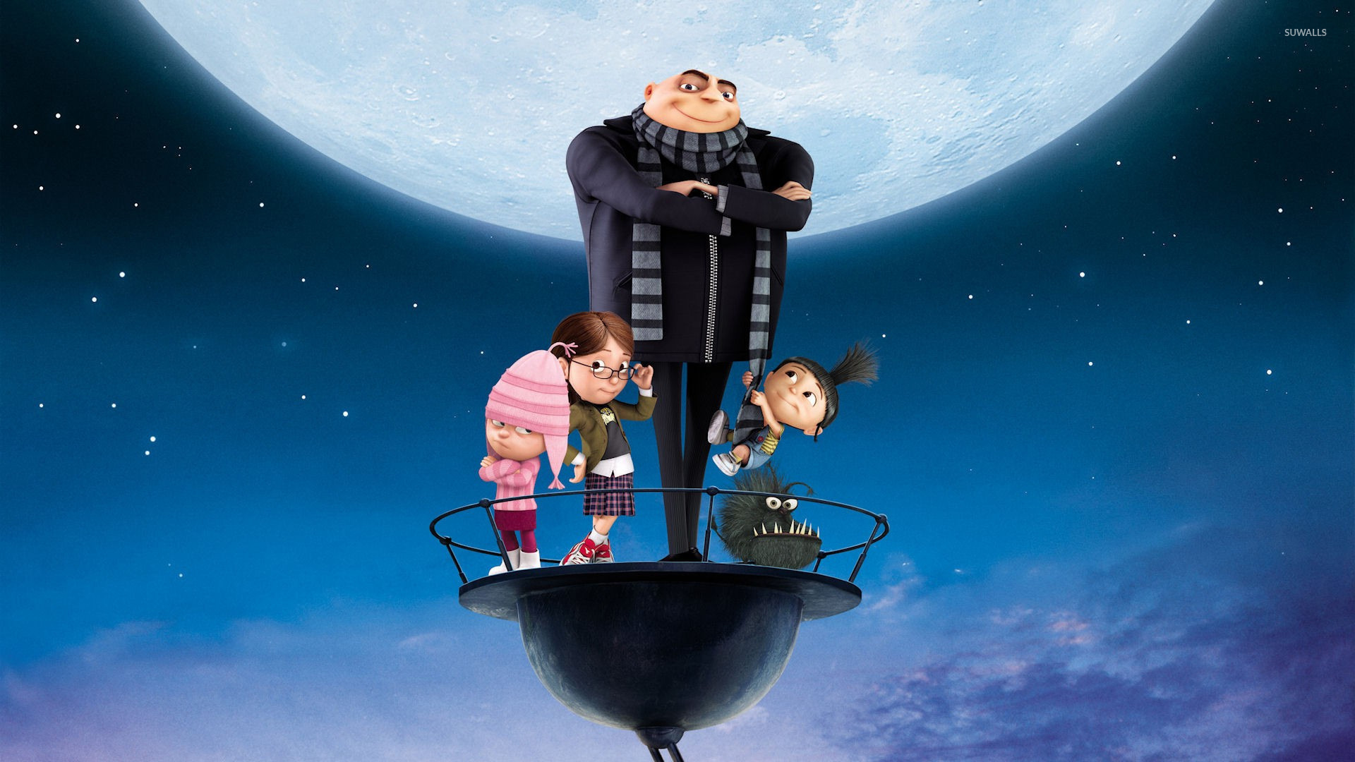Despicable Me characters standing on a platform against a large moon backdrop