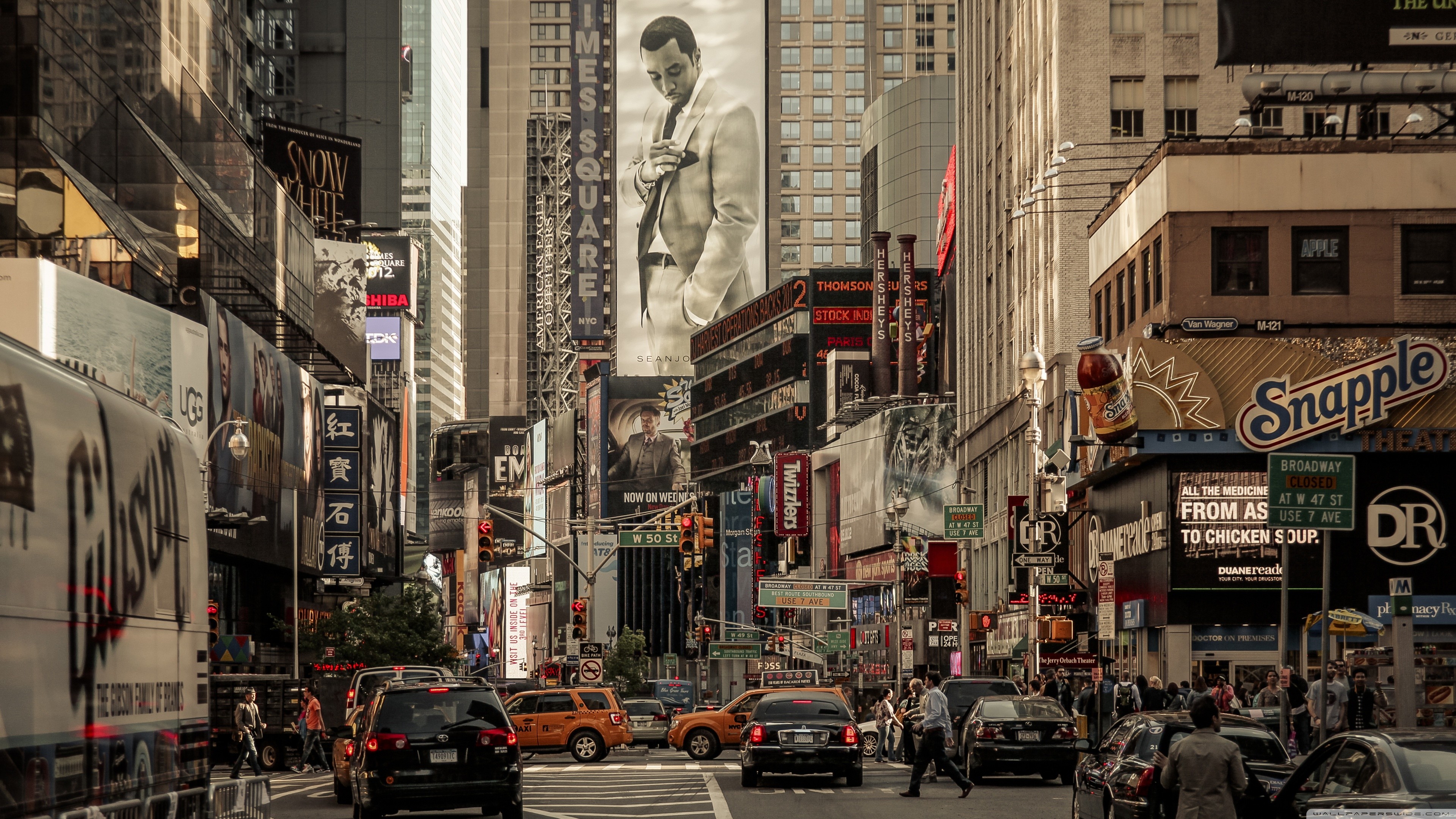 A bustling view of Times Square on Broadway in New York City, showcasing the vibrant atmosphere with bright billboards, traffic, and pedestrians