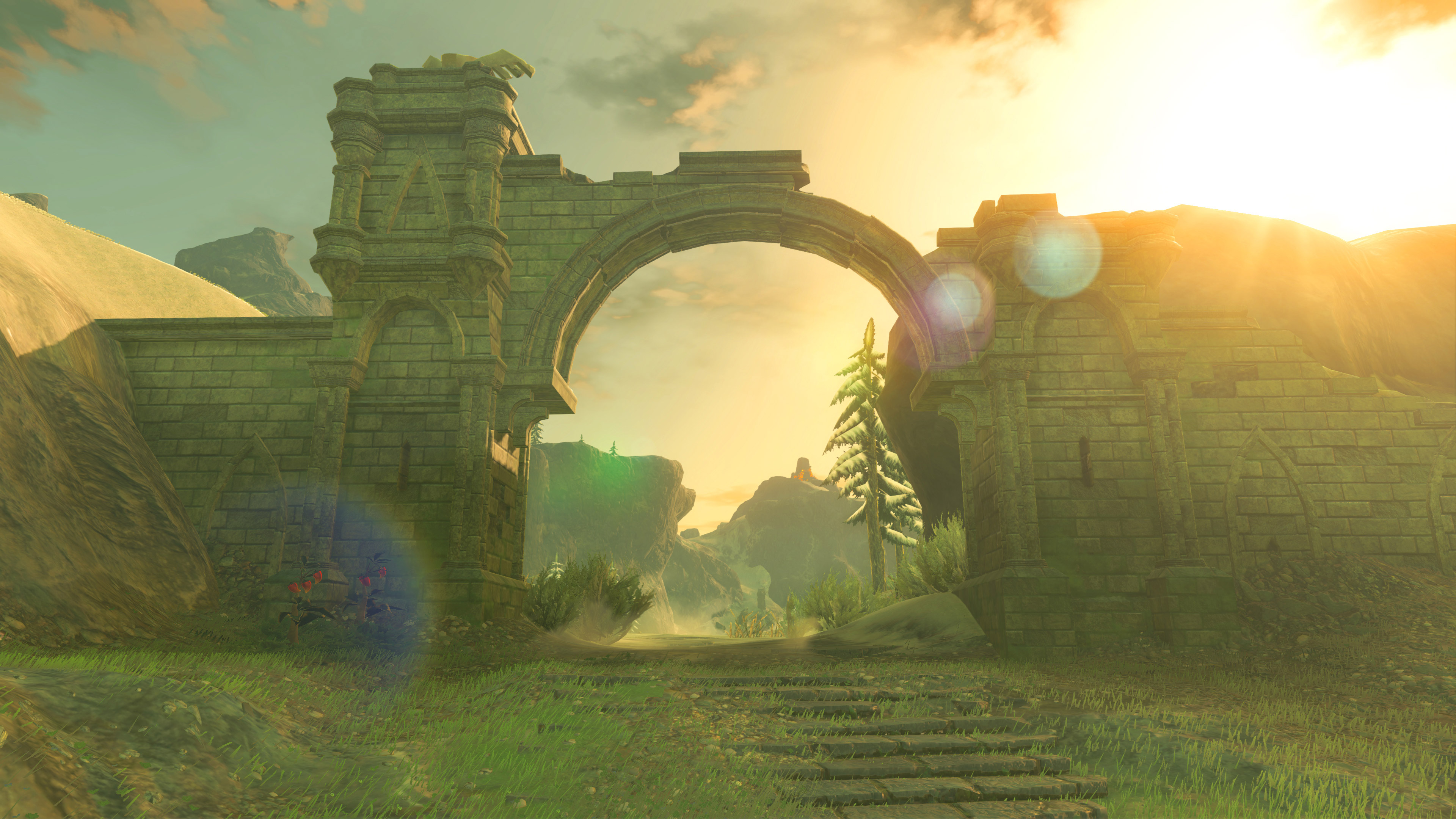 A picturesque view through a crumbling stone archway in the Legend of Zelda: Breath of the Wild, showcasing the sun-drenched landscape