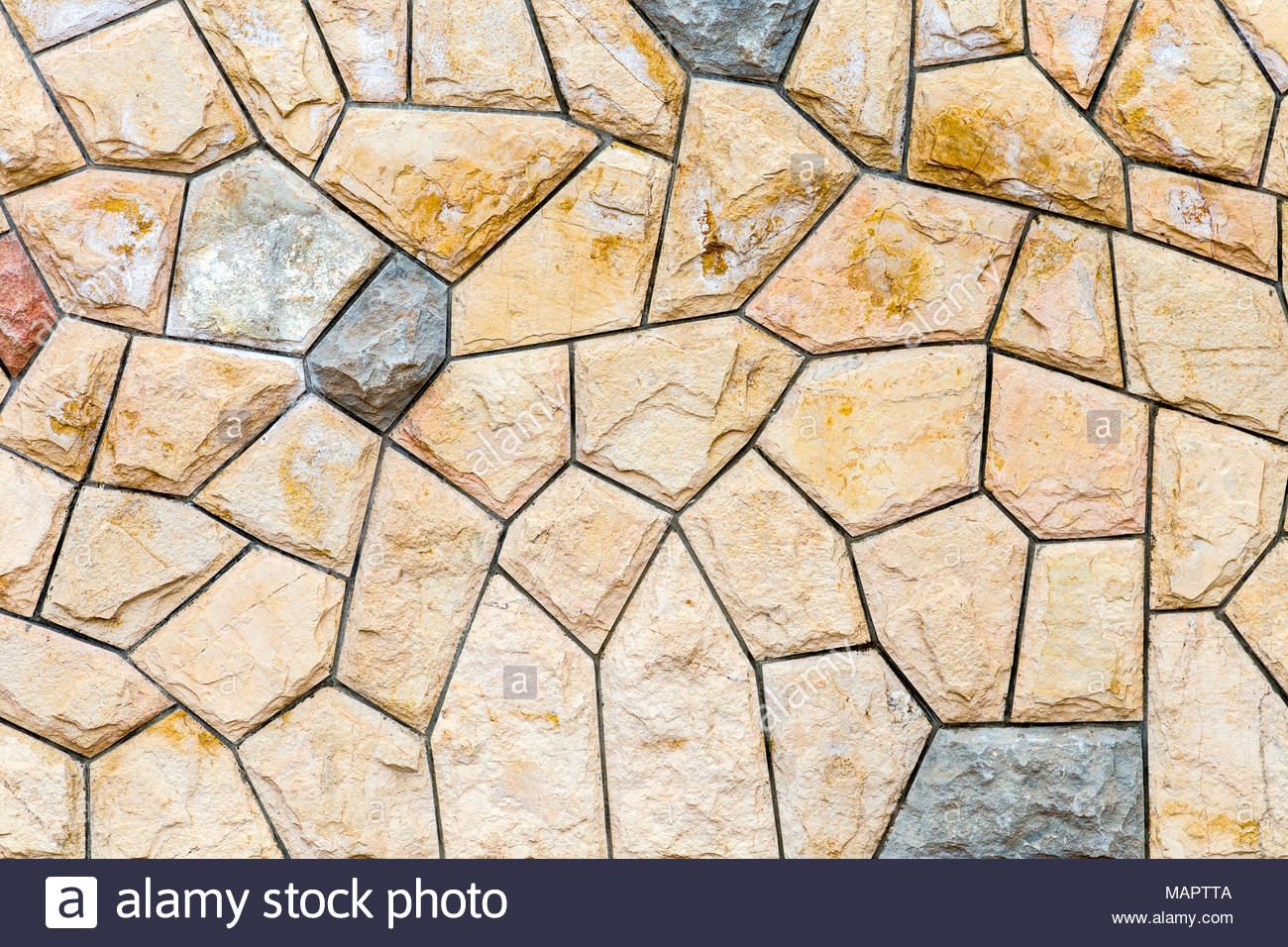 Stone wall made of asymmetrical tiles background Stock Photo 1300x956