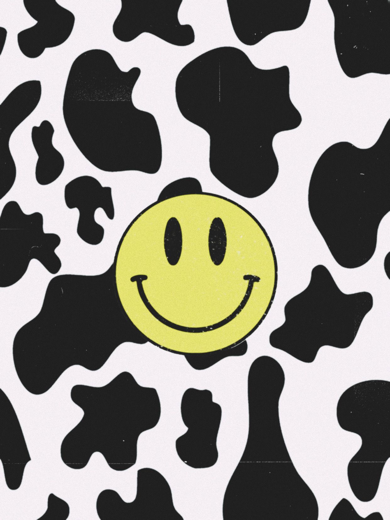 A cheerful yellow smiley face on a cow print background, perfect for a vibrant and playful wallpaper