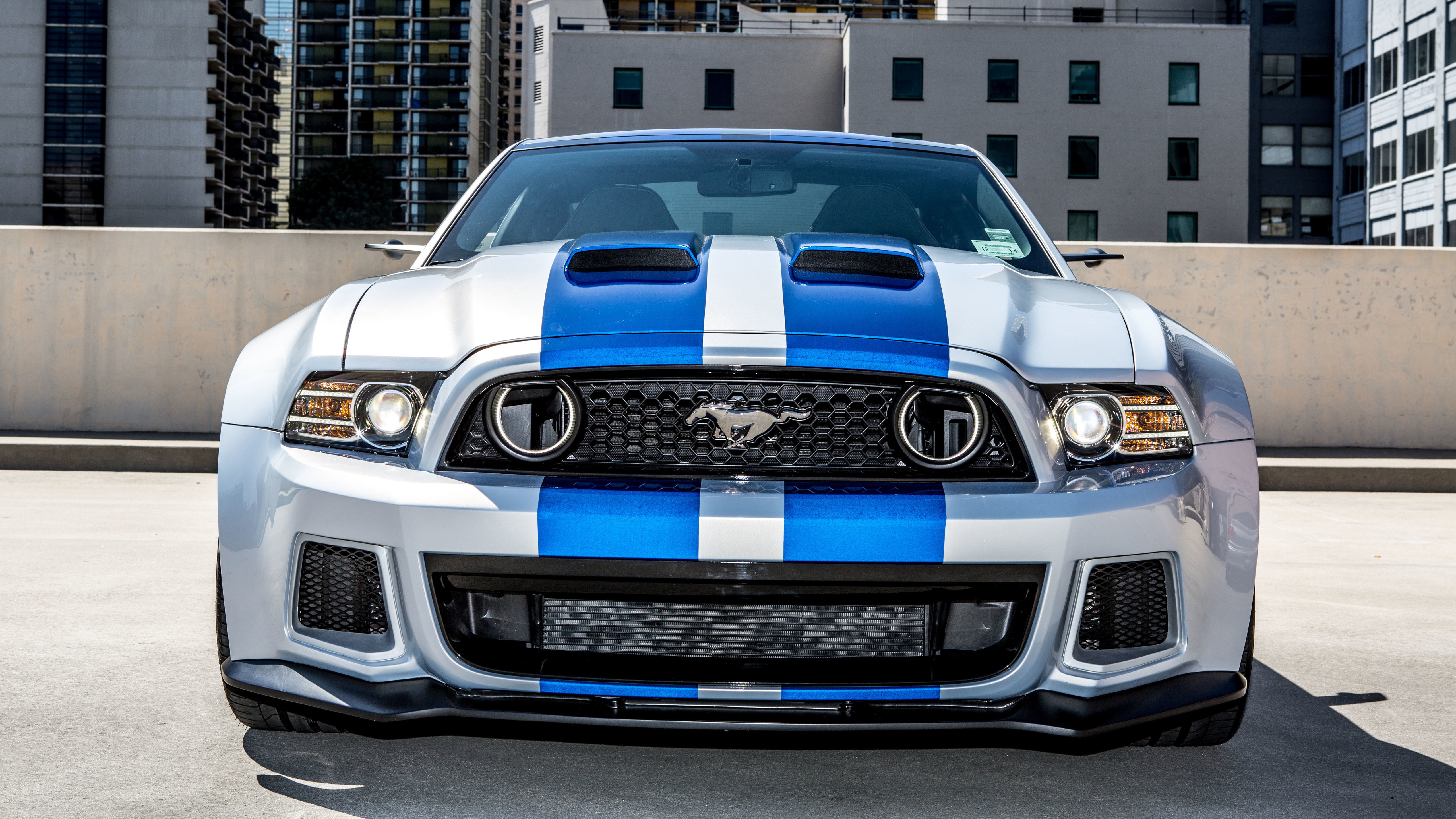 A front view of a silver and blue Ford Mustang sports car