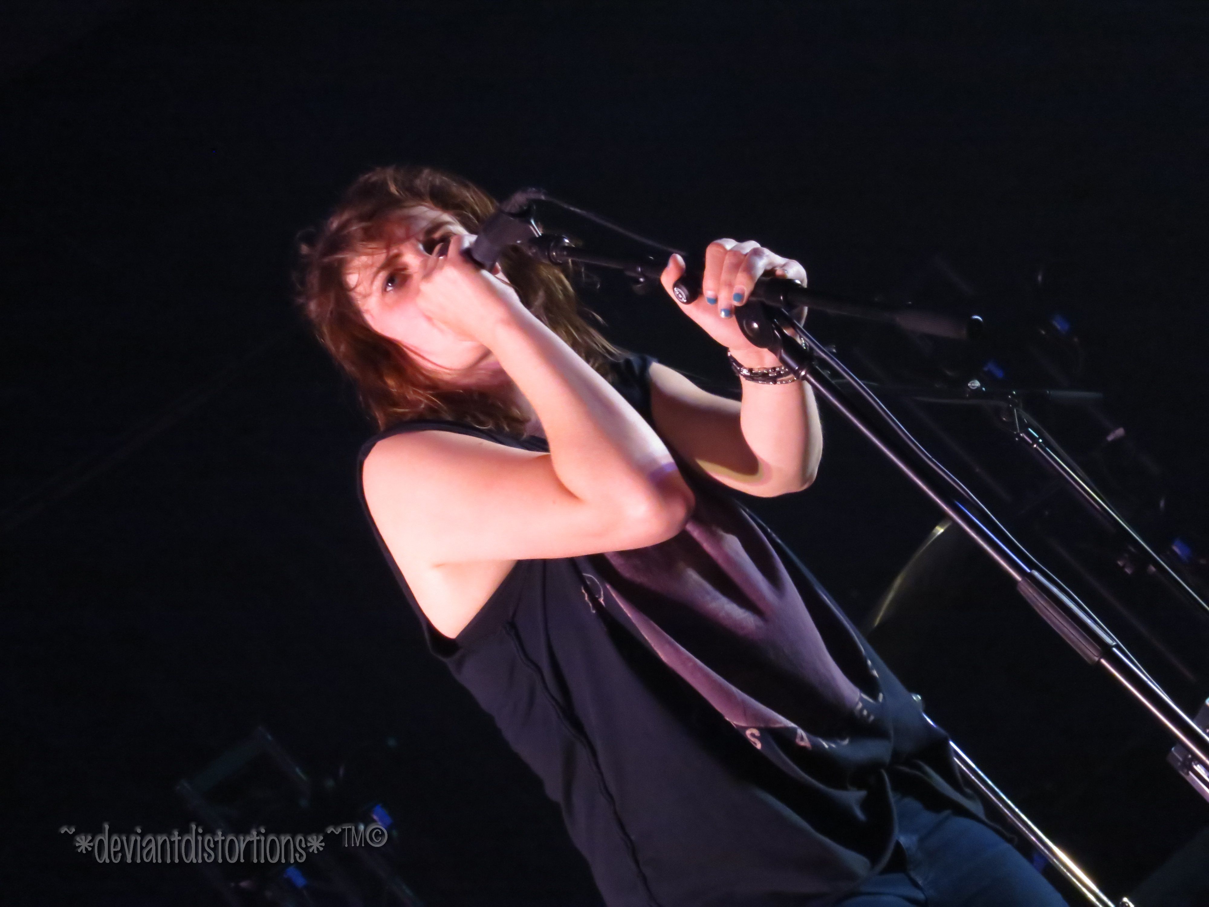 Emily Armstrong of Dead Sara singing passionately into a microphone on stage