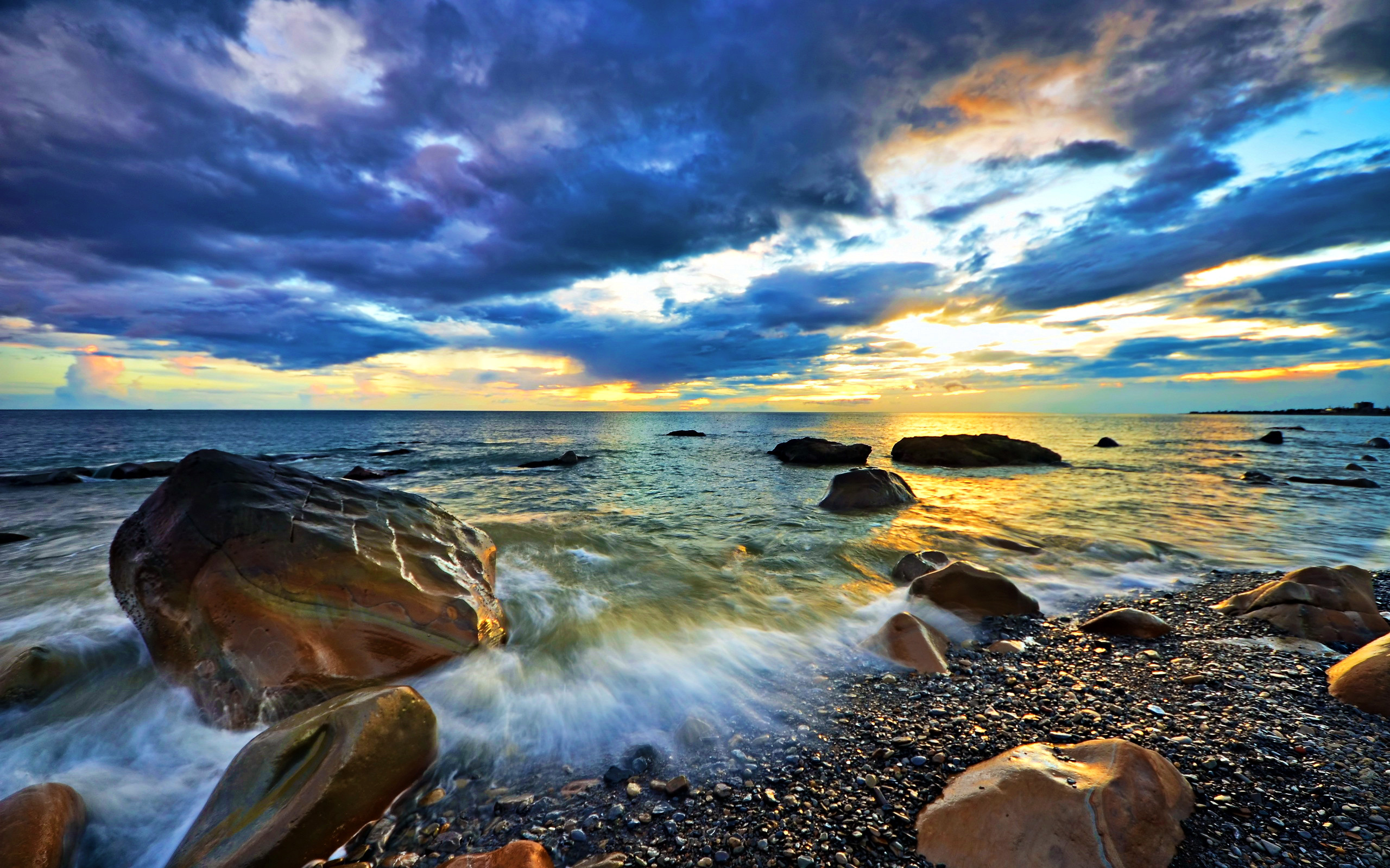Rocky ocean shore at sunset with vibrant colors and dynamic waves