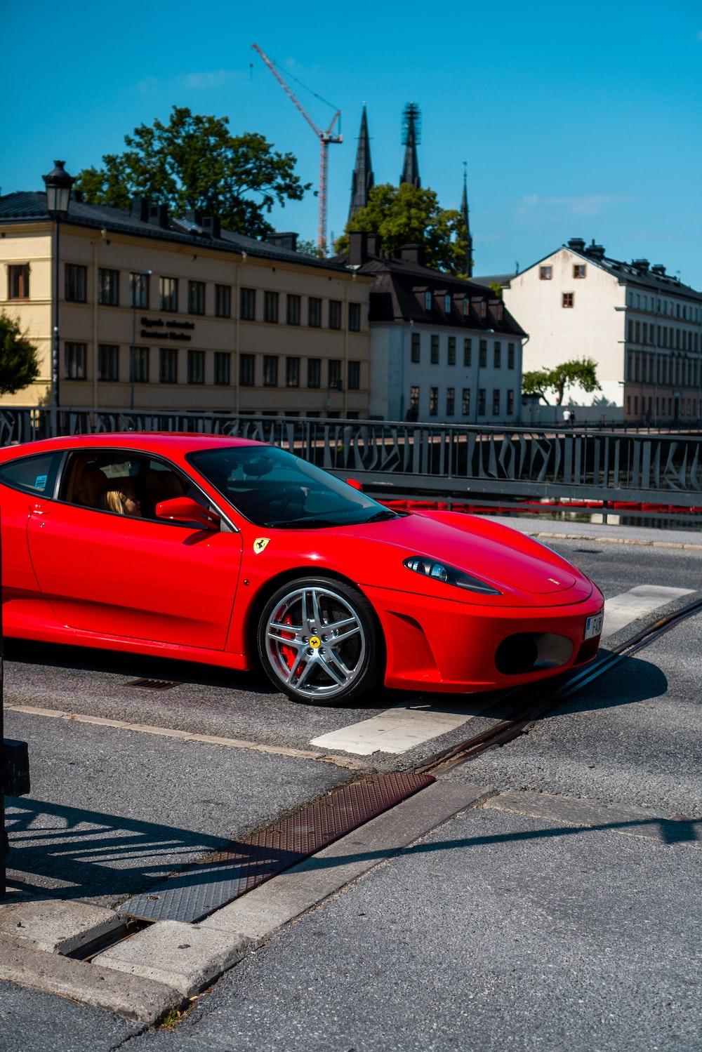 Red Ferrari Italia Parked On Sidewalk During Daytime Photo