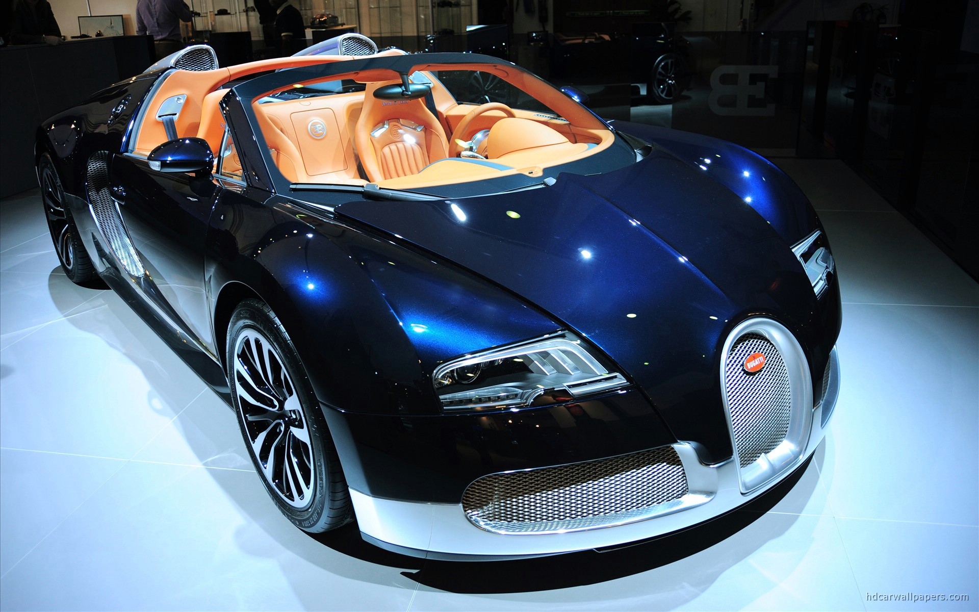 A stunning, dark blue Bugatti Veyron convertible on display, highlighting its luxurious interior and sleek exterior design