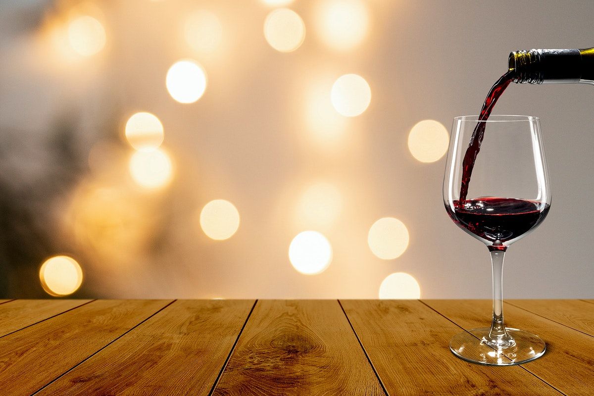 A Glass Of Red Wine Is Being Poured Into The Goblet On Wooden Table Wallpaper
