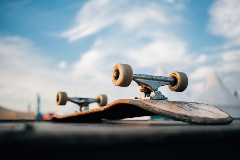 Black Skateboard On Brown Soil Photo Wheels Image