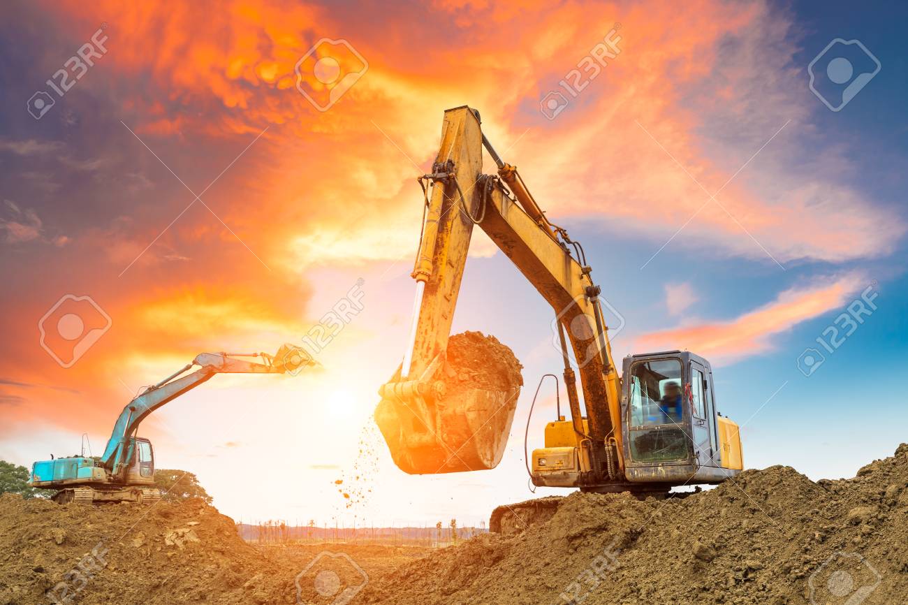 Excavator In Construction Site On Sunset Sky Background Stock