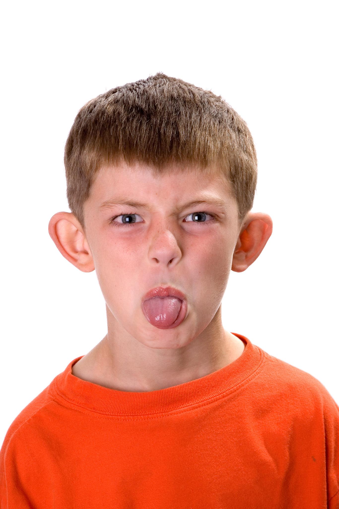 Young Boy Sticking Out His Tongue On A White Background The