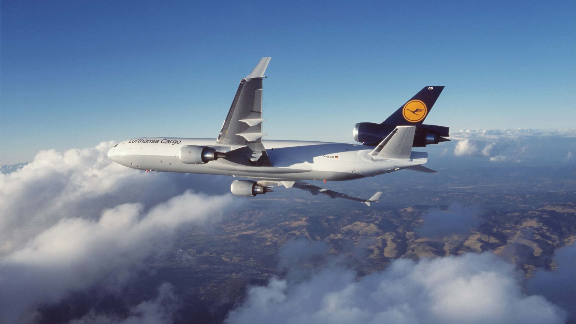 A Lufthansa Cargo MD-11F soars through the sky, its white fuselage contrasting against the deep blue. This powerful cargo aircraft is a testament to global trade and logistics