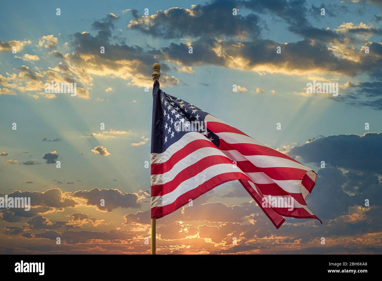 American Flag On Wood Pole Against Sunset Stock Photo