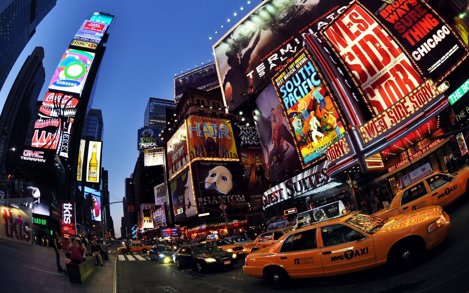 A vibrant night scene in New York City's Times Square, showcasing Broadway show advertisements and the iconic yellow taxis