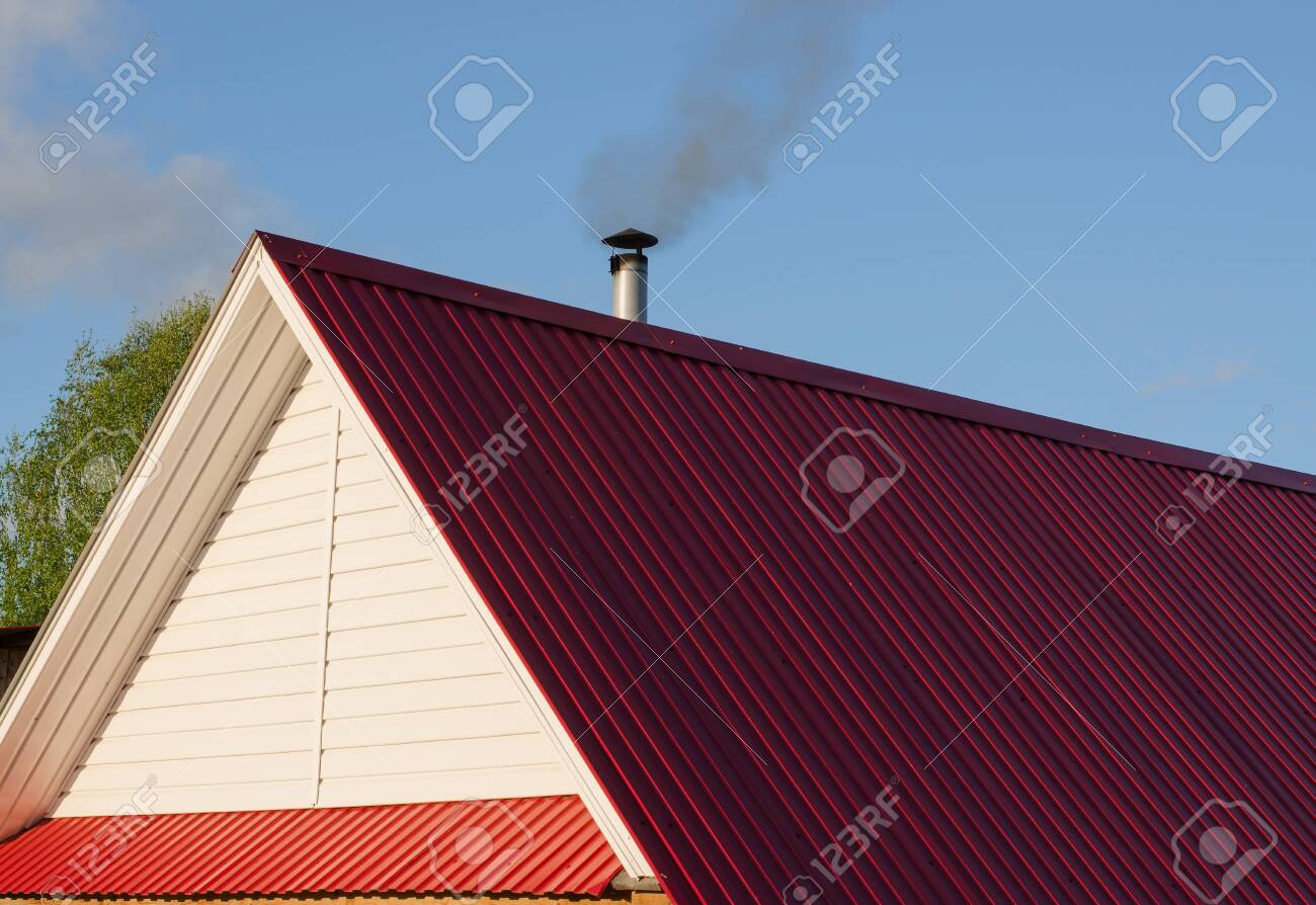 Tiled Roof Top With Chimney Blue Cloudy Sky In Background