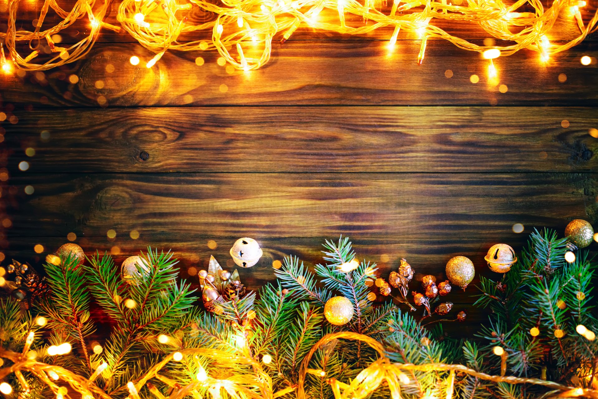 Christmas lights and fir branches on a rustic wooden background, creating a festive 4k wallpaper