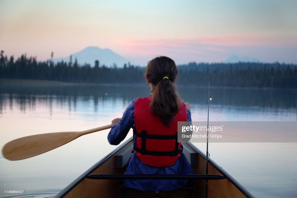 Girl Paddling Canoe On Hosmer Lake At Dusk Mountain Bachelor In