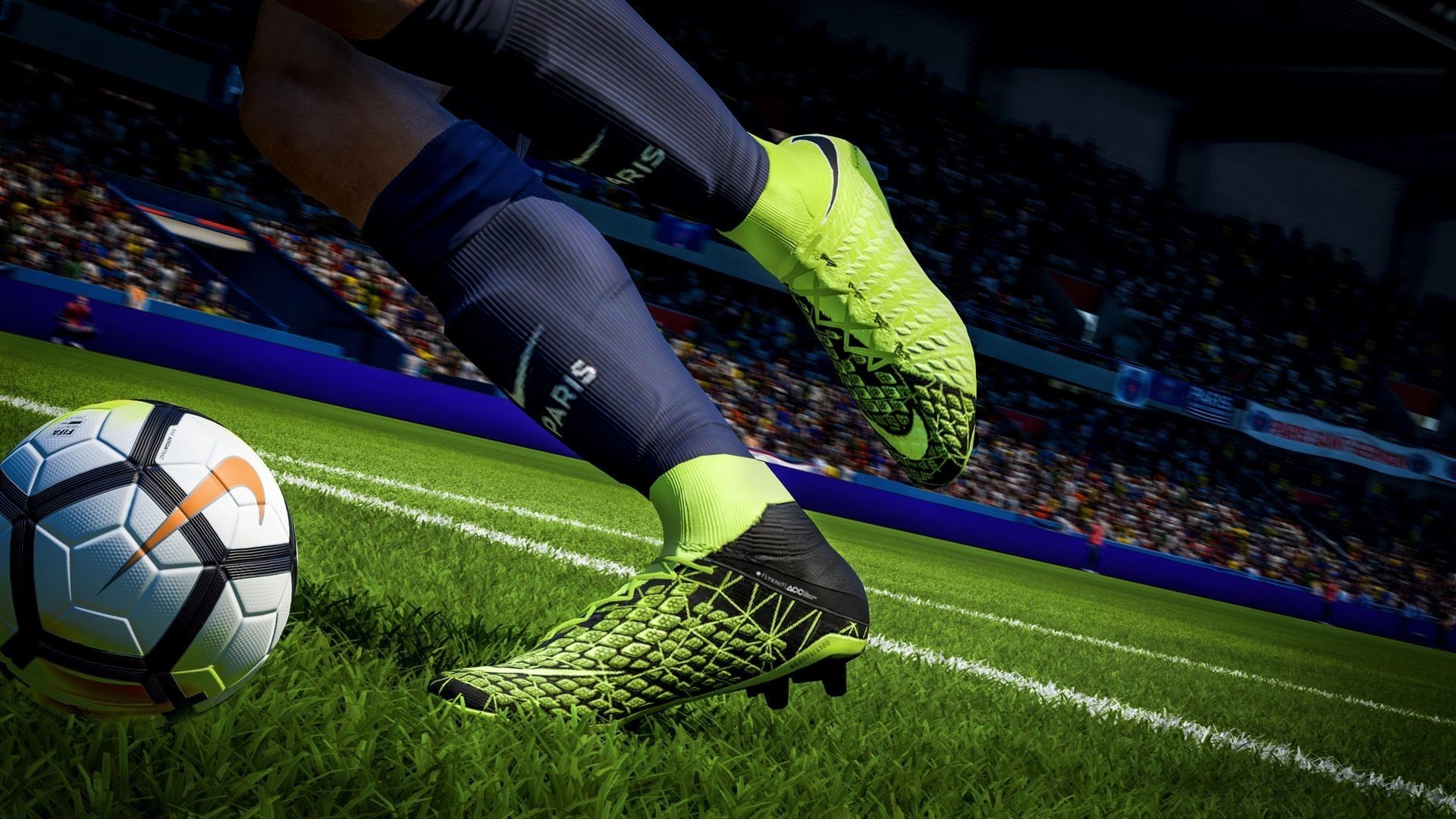 Close-up of Nike football boots kicking a Nike soccer ball on a vibrant green field during a match, with a blurred stadium background