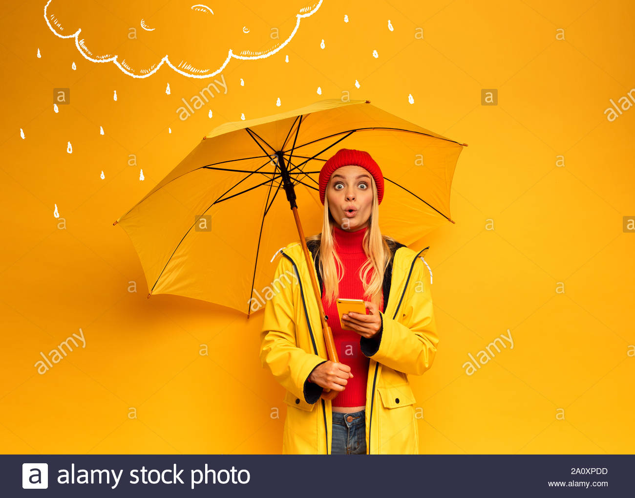 Girl With Smartphone And Umbrella On Yellow Background Surprised