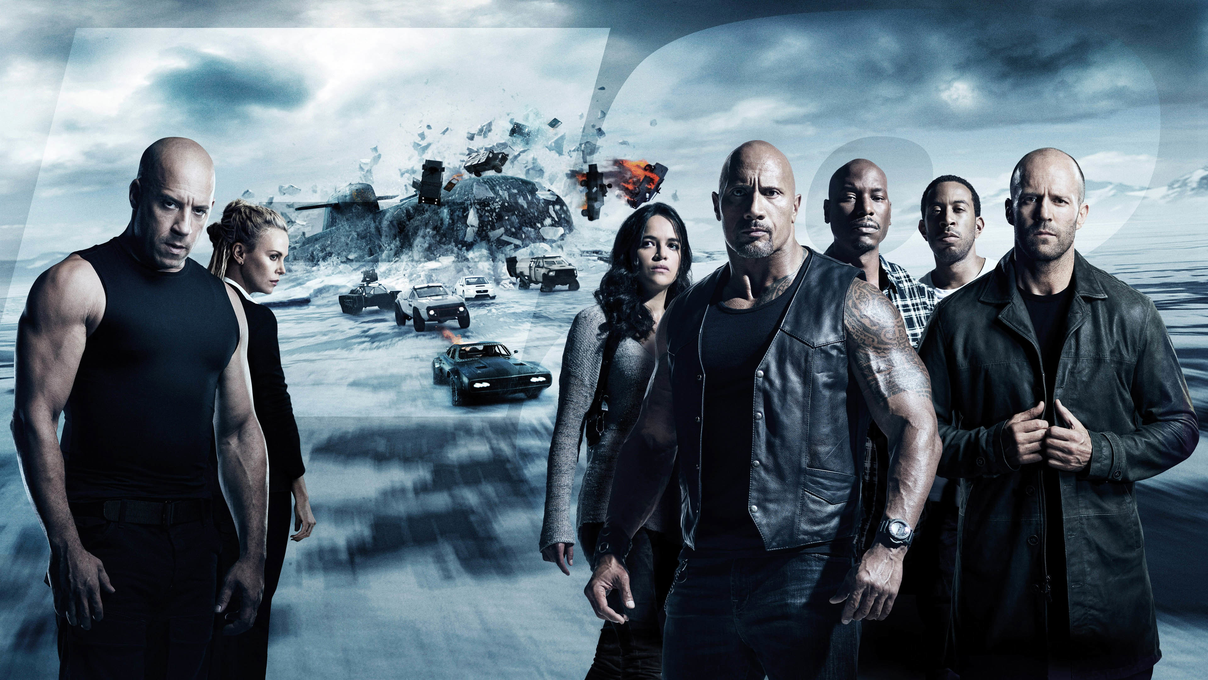 The cast of Fast & Furious 8 standing strong against a snowy backdrop with speeding cars