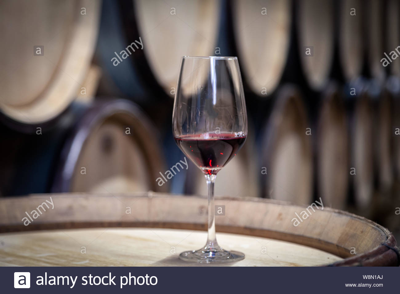 Closeup Glass With Red Wine On Background Wooden Oak Barrels