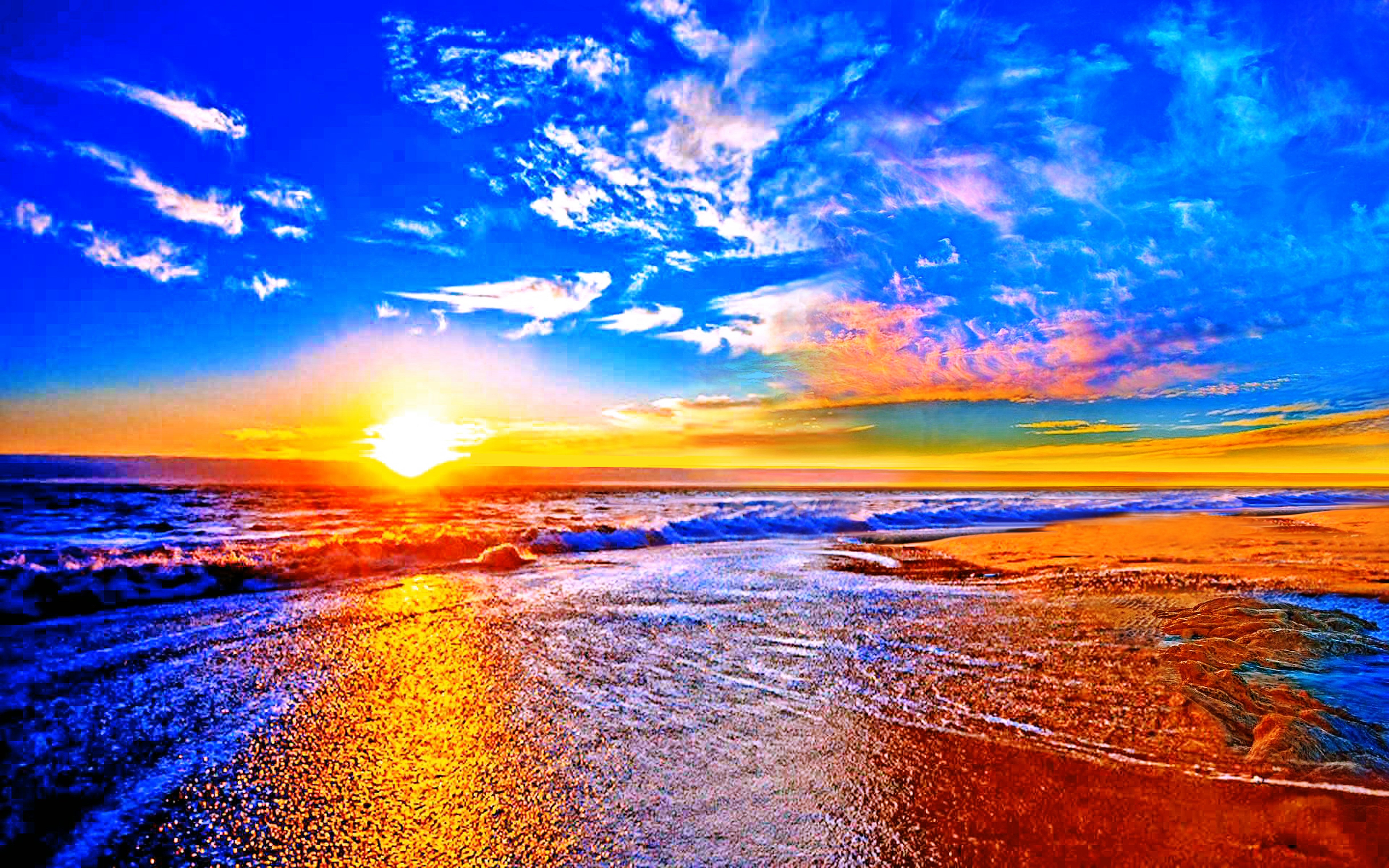 Vivid sunset over the ocean with vibrant colors reflecting on the wet sand