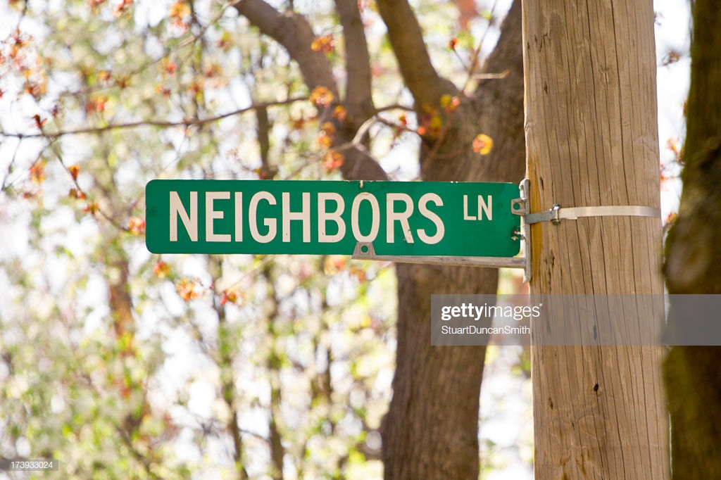 Street Sign Labelled Neighbors Ln With Trees In Background Stock
