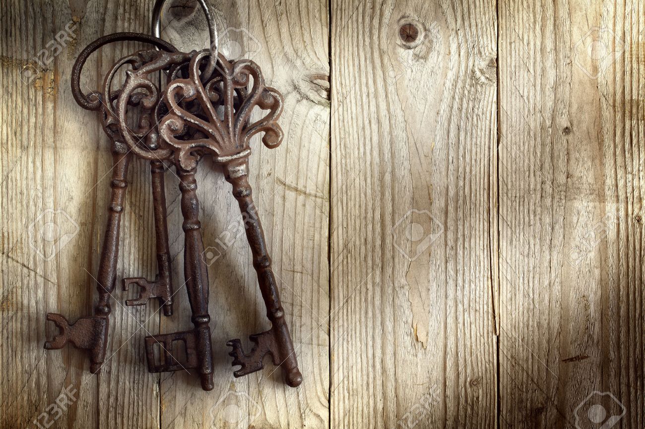 Old Skeleton Keys Hanging Against A Wooden Background Stock Photo
