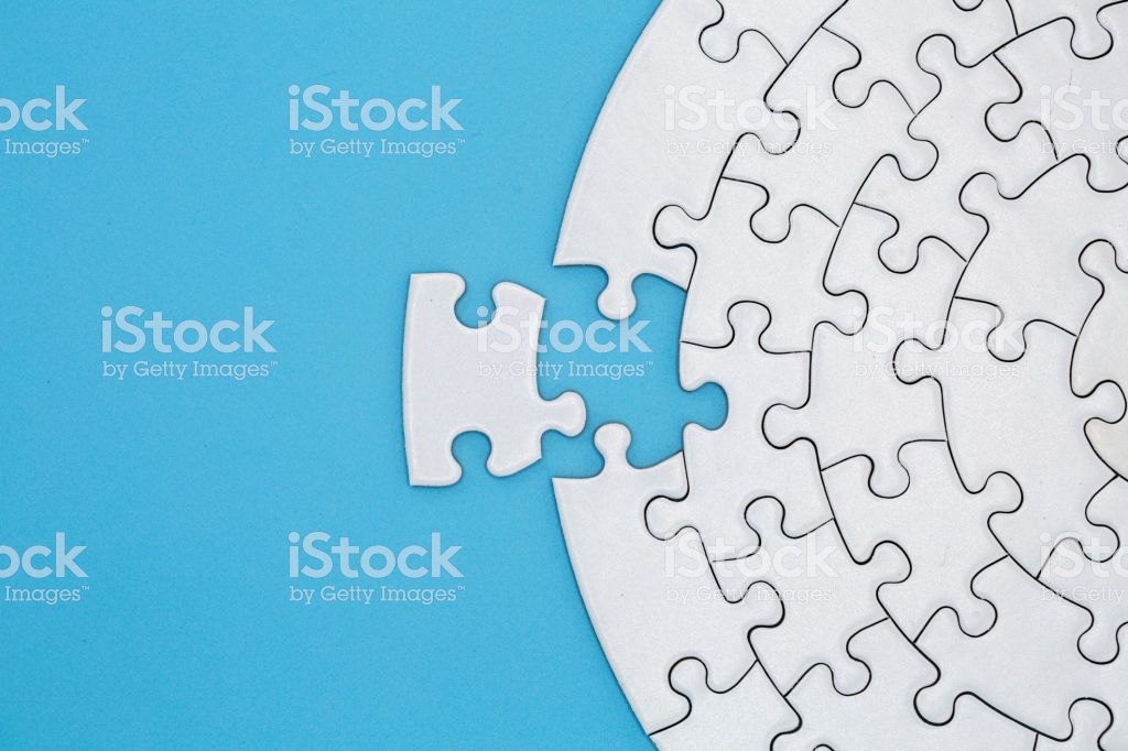 Unfinished White Jigsaw Puzzle Pieces On Blue Background The Last