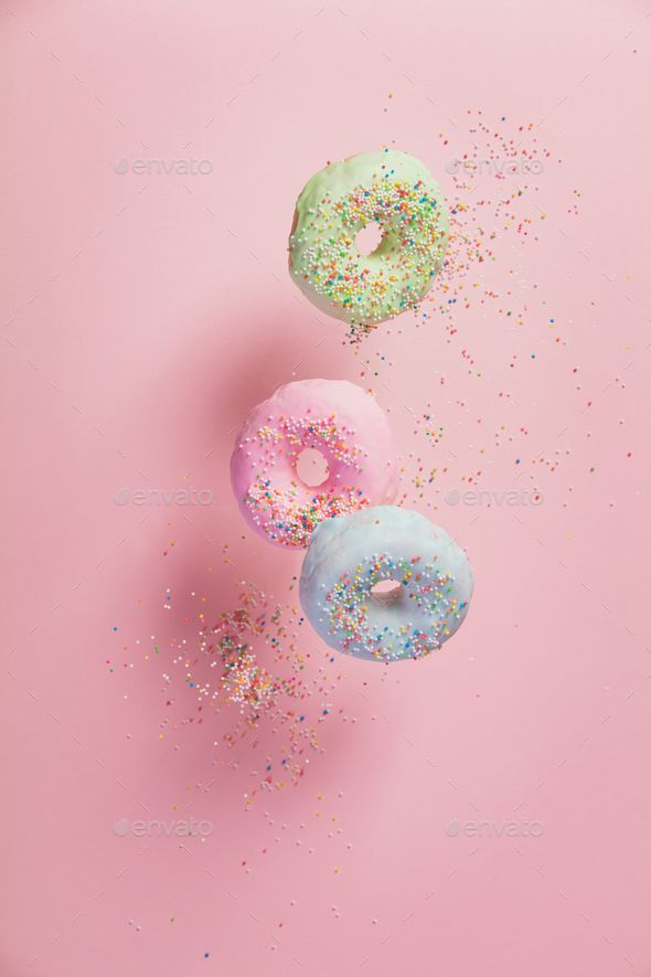 Sweet and colourful doughnuts with sprinkles falling or flying i 590x885