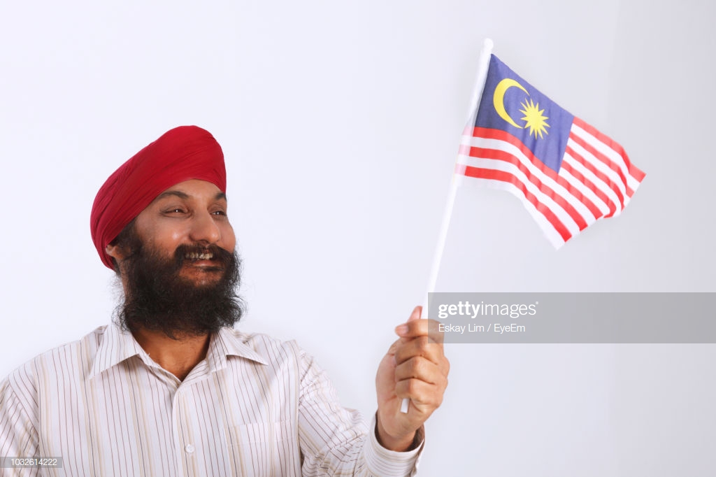 Man Holding Malaysian Flag Against White Background Stock Photo