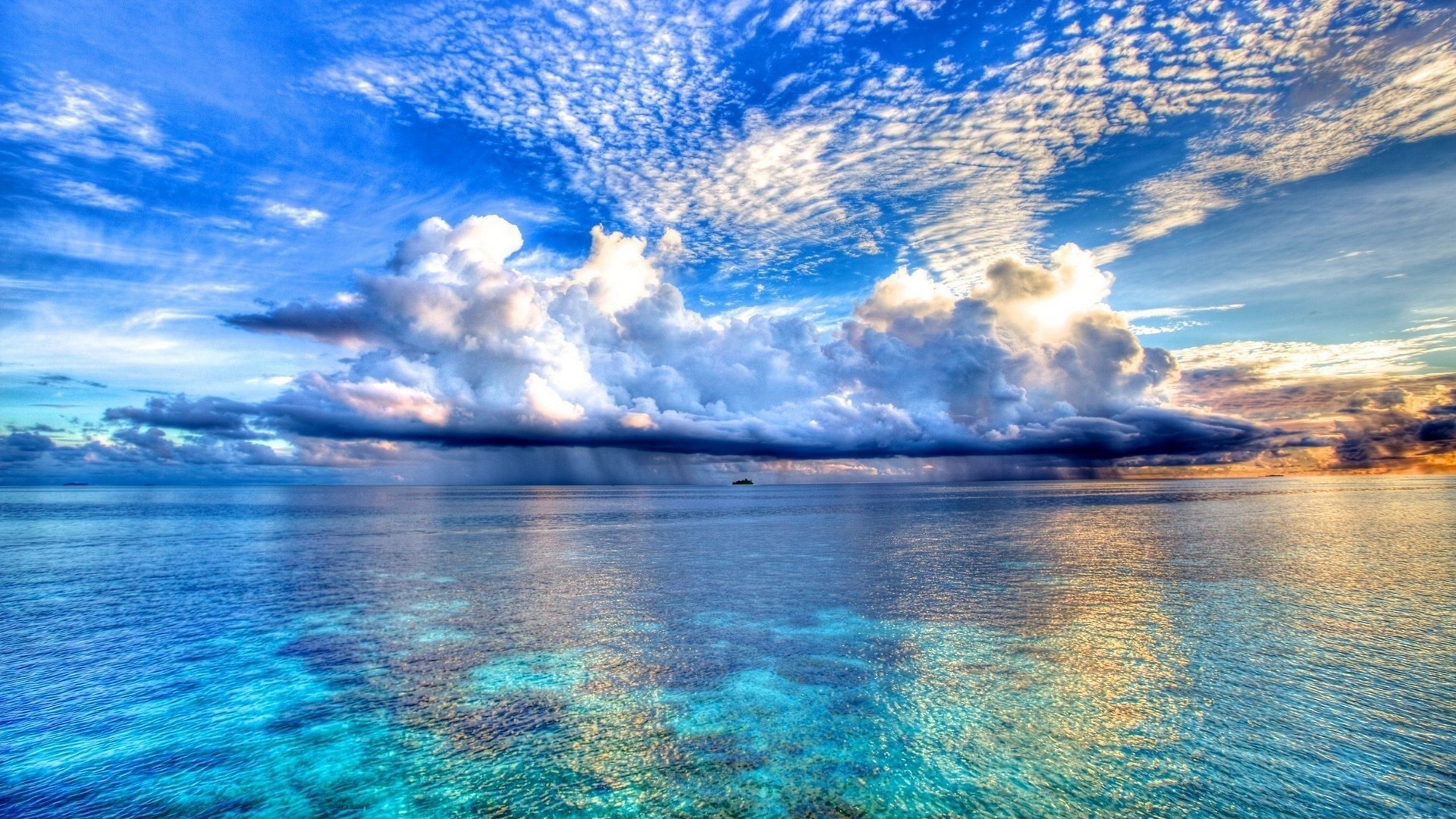 A breathtaking seascape with turquoise water, a dramatic cloudscape, and a distant rain shower