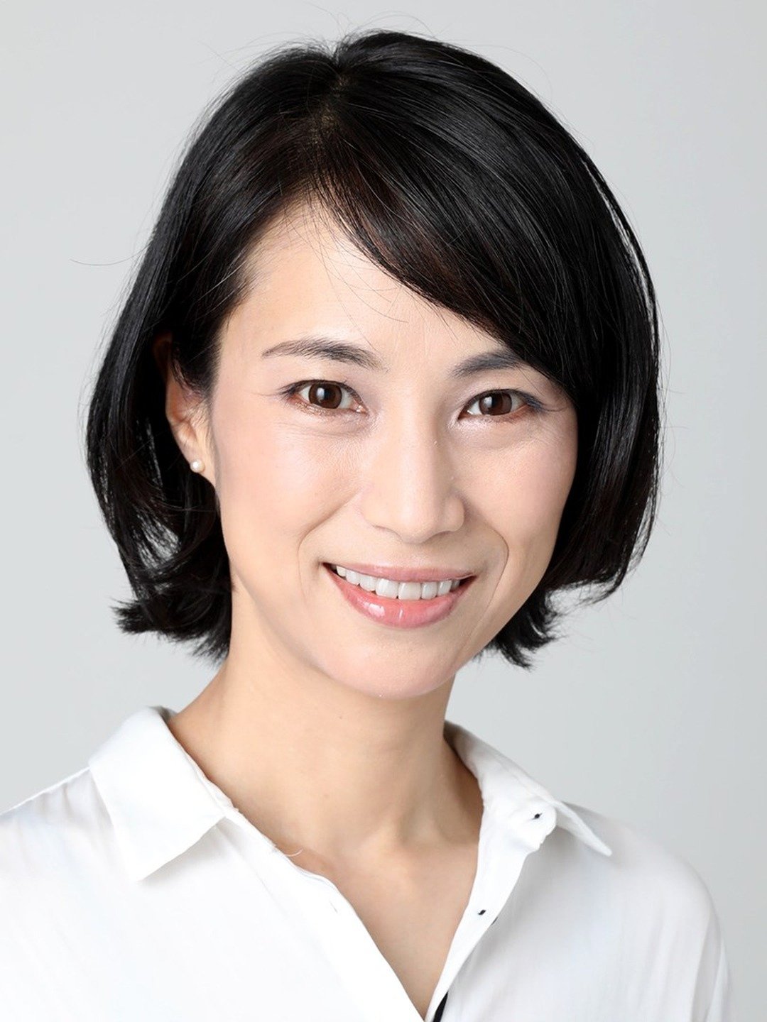 Headshot of a woman with short black hair and a white shirt