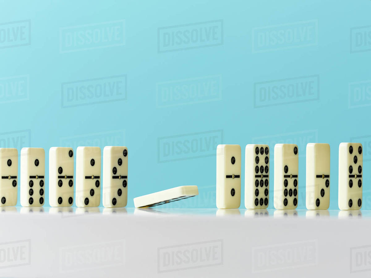 Domino Falling In A Row On Blue Background Stock Photo Dissolve