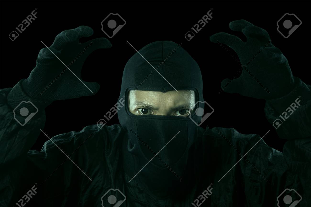 Portrait Of Dangerous Bandit In Dark Background Stock Photo