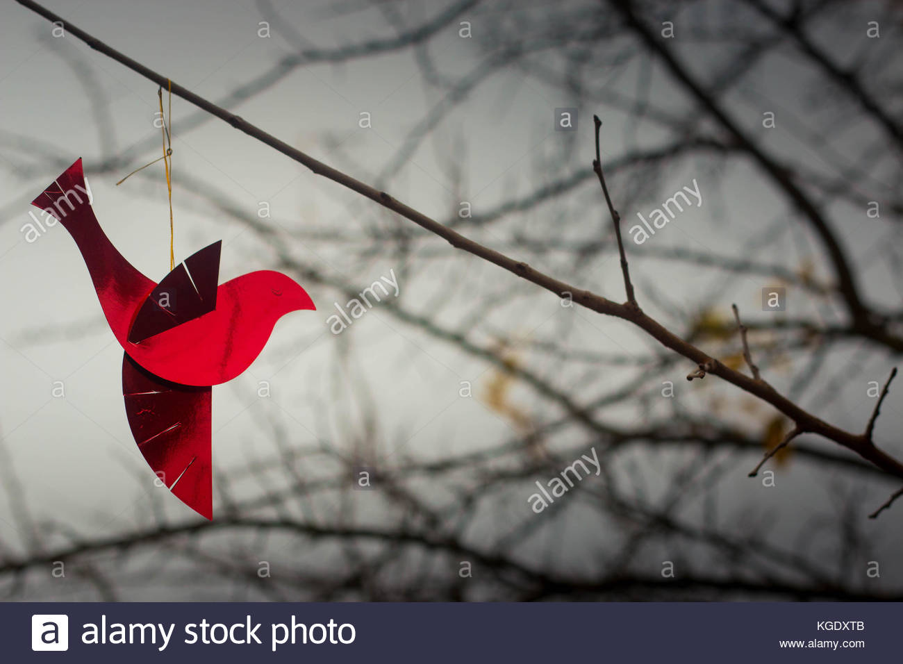 Shiny Red Bird Ornament On A Branch With Cold Winter Sky In The
