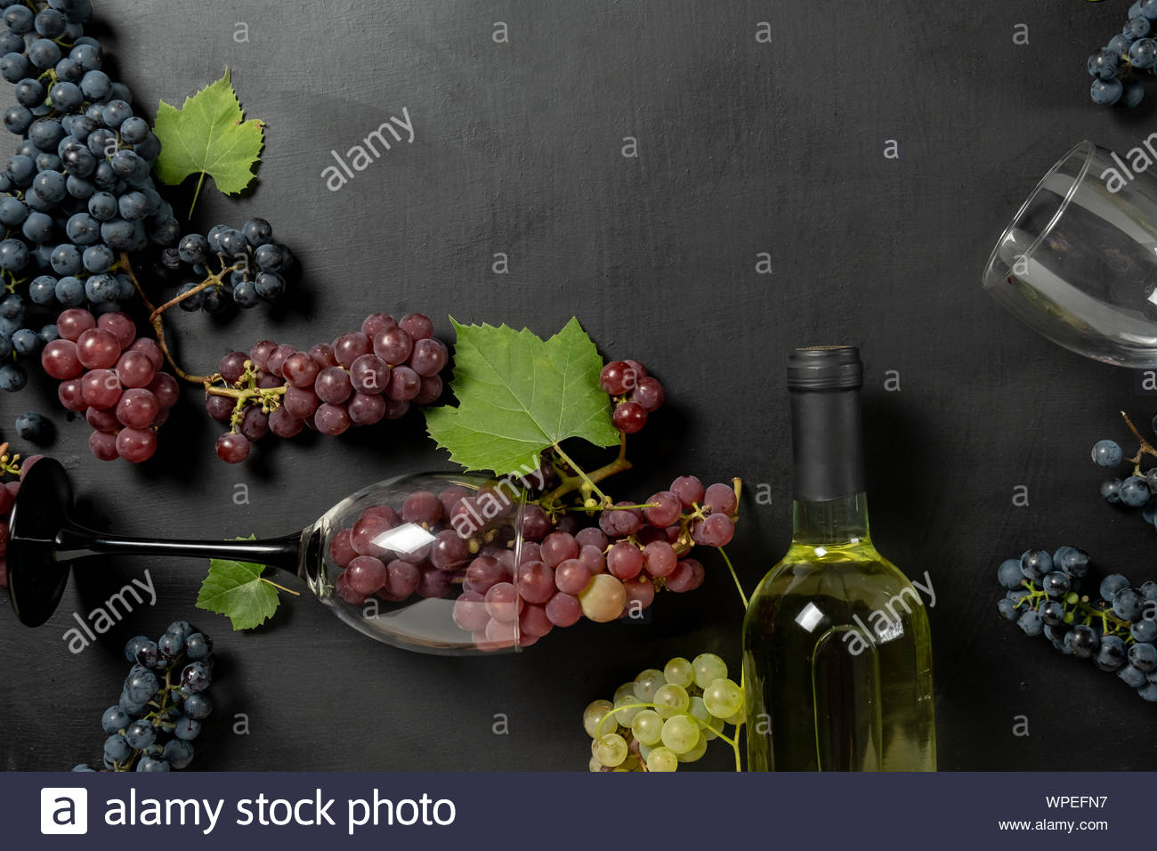 Bottle Two Wine Glasses Fresh Grapes And Leaves On Black