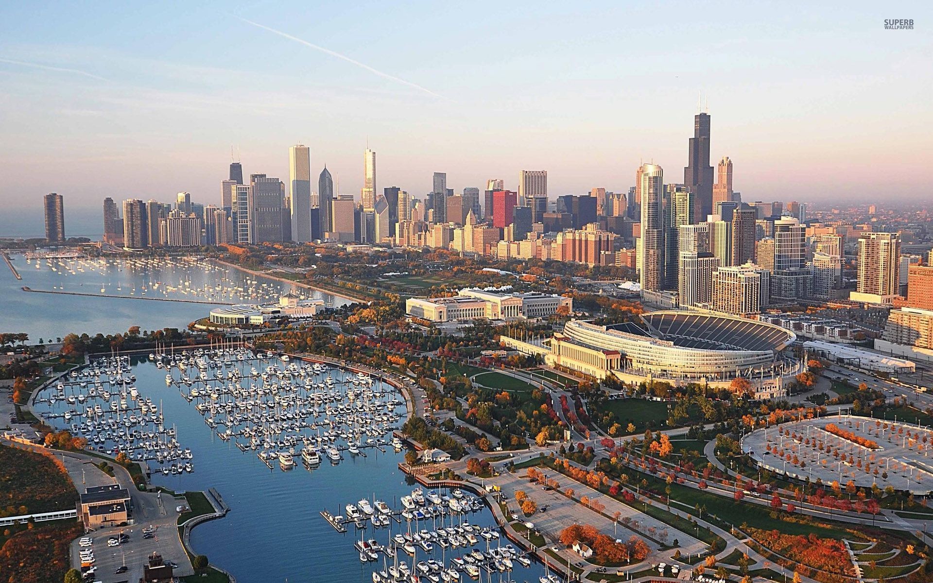 Aerial view of the Chicago skyline at sunset with Soldier Field and the harbor in the foreground