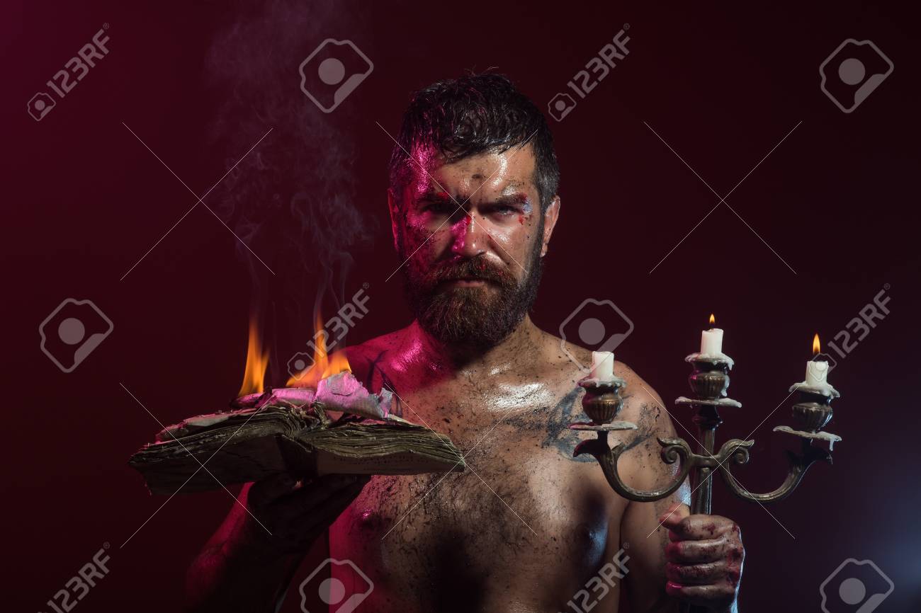 Hipster Man Hold Book And Candles Burning On Purple Background