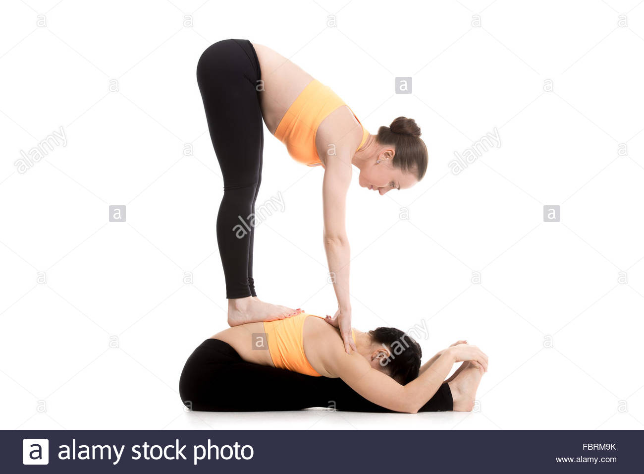 Two Sporty Girls In Orange Sportswear On White Background Doing